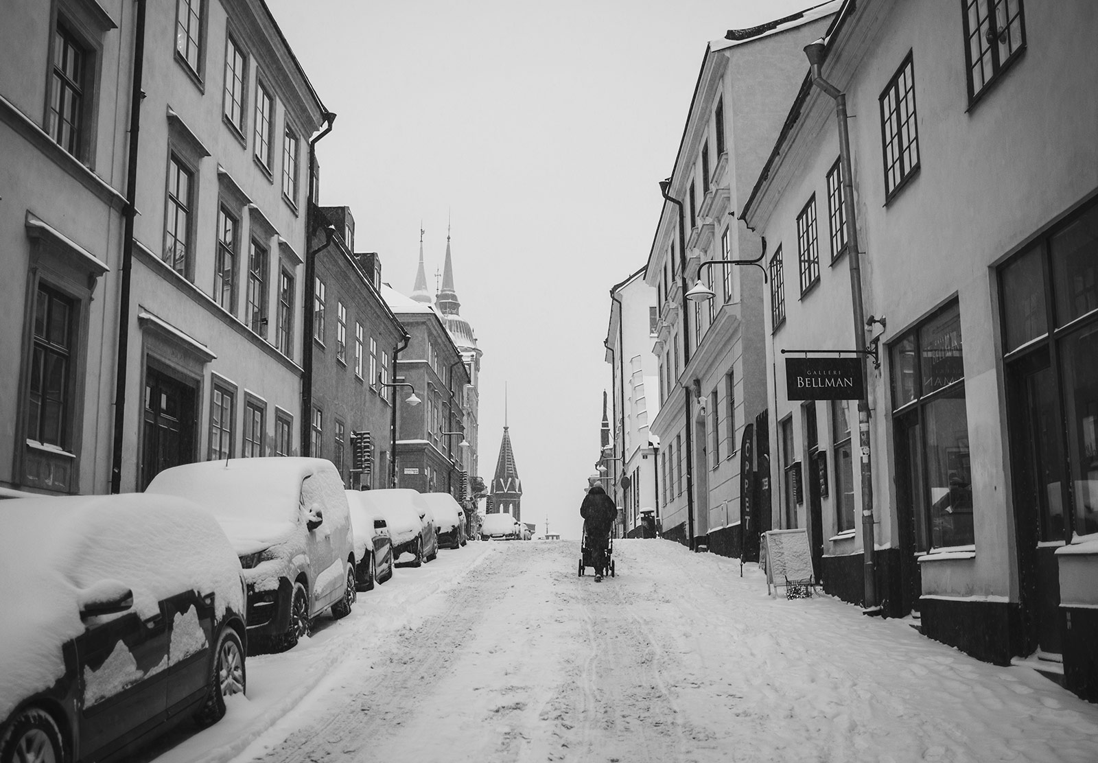 Person walking up old street in the snow