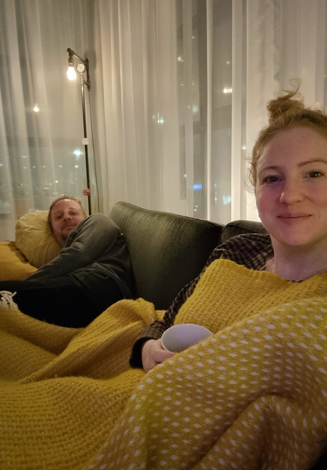 Couple sat under blanket