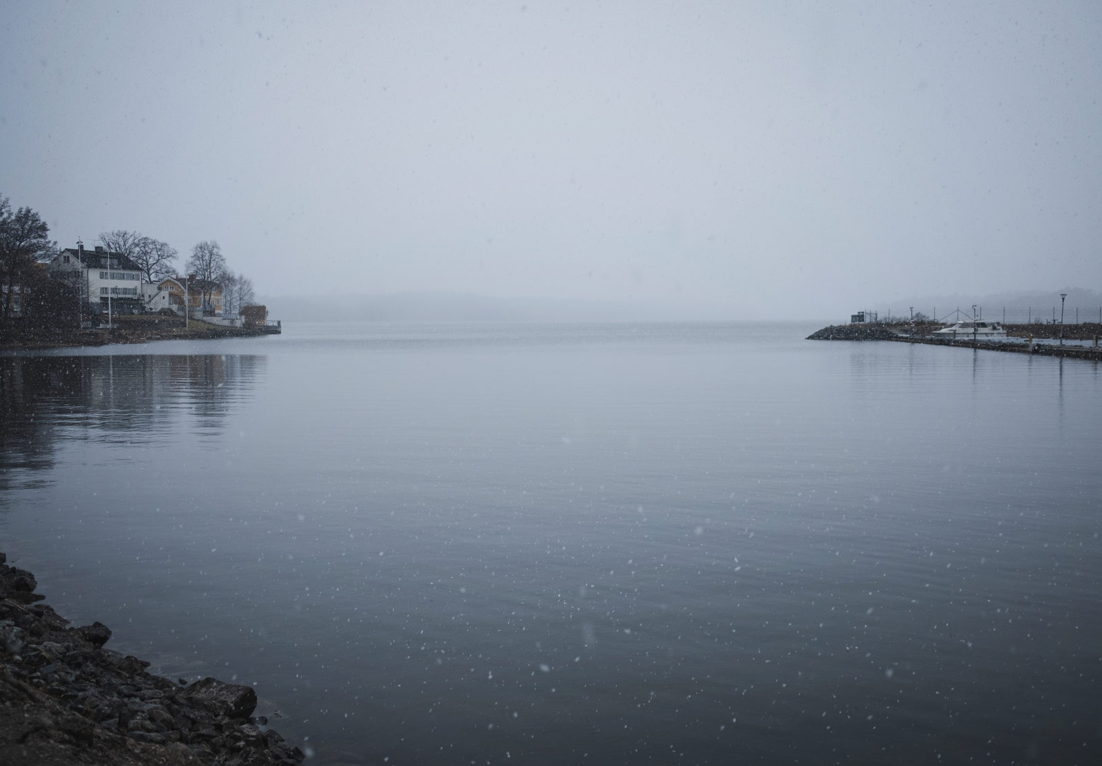 Snow falling over water