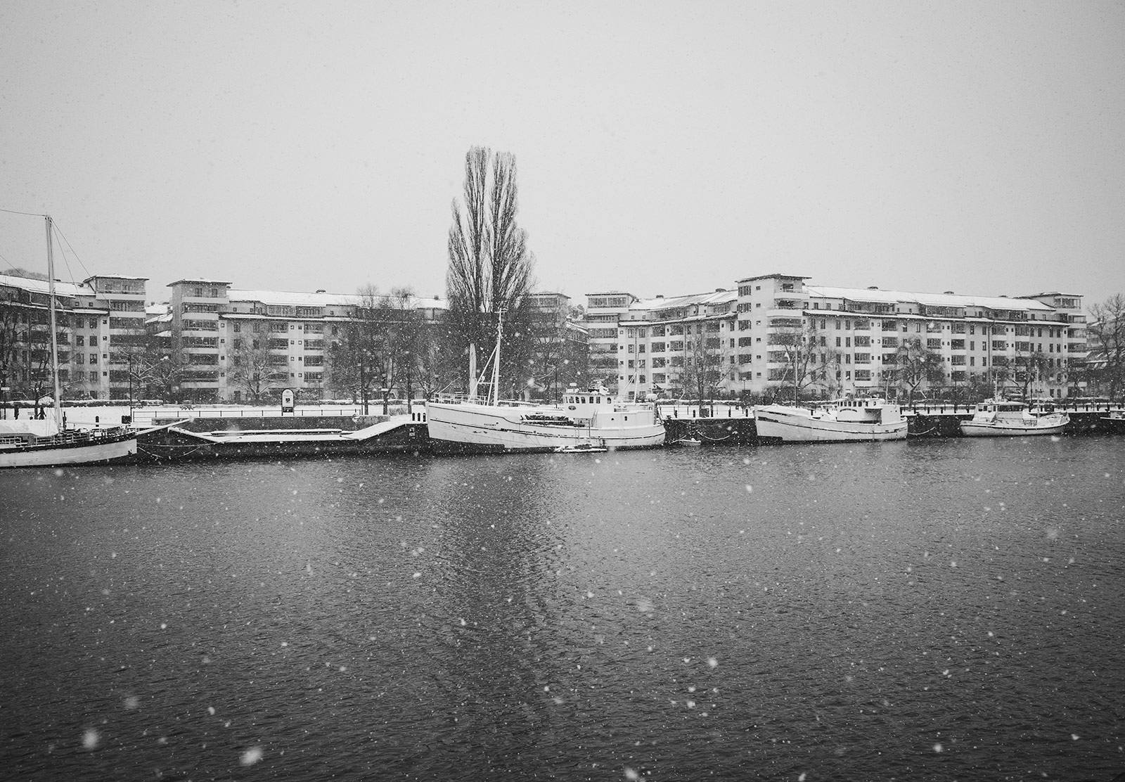 Snow falling with boats in the background