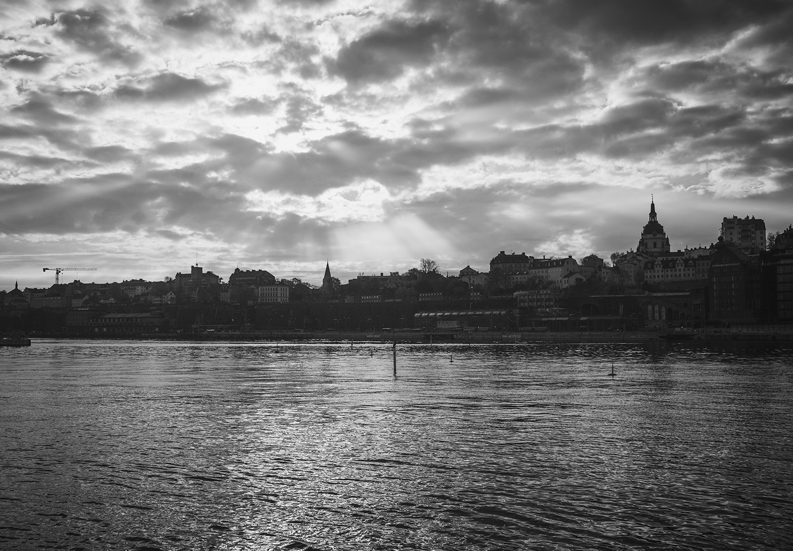Light shining onto old buildings, through clouds