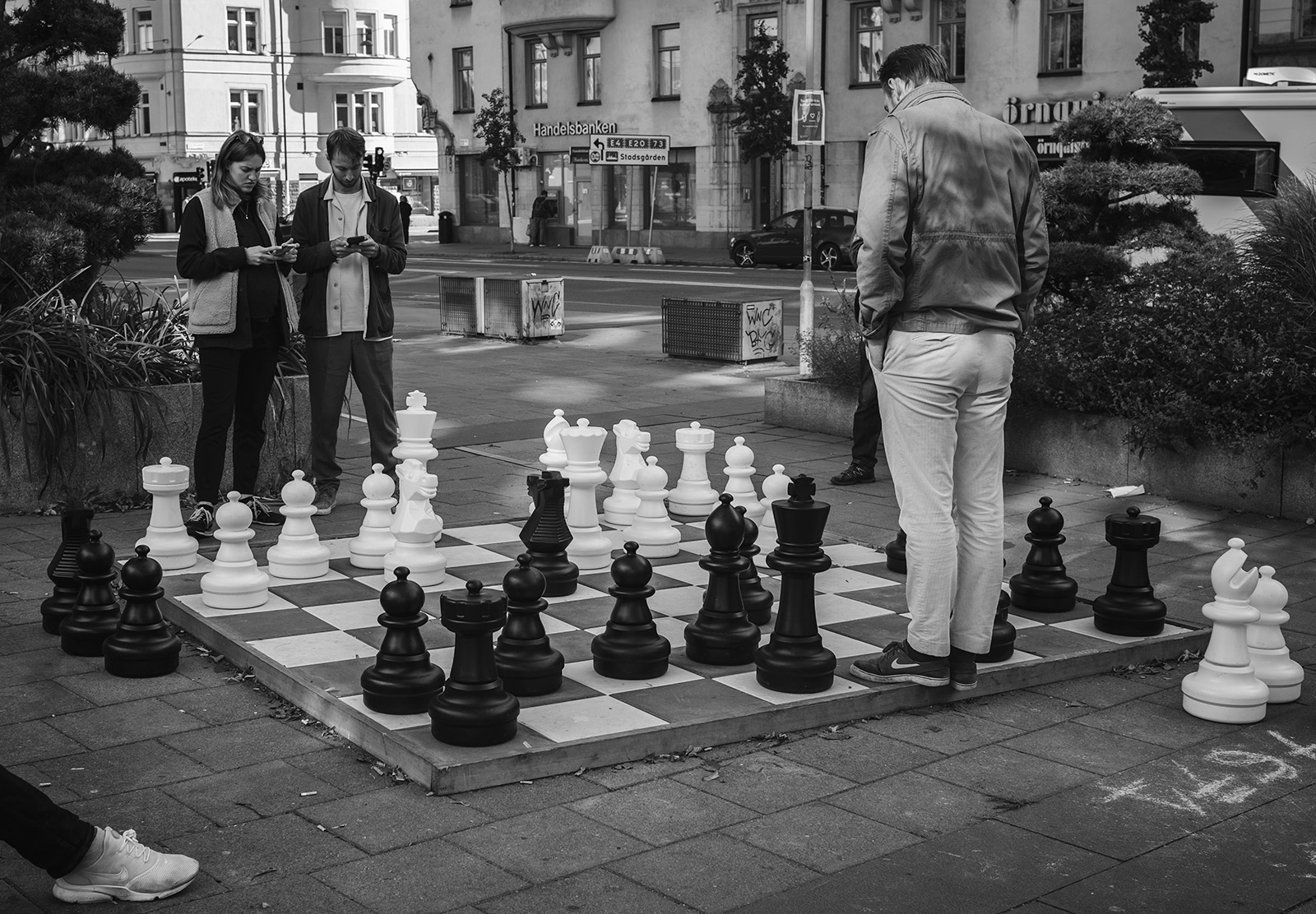 People standing at giant chess board