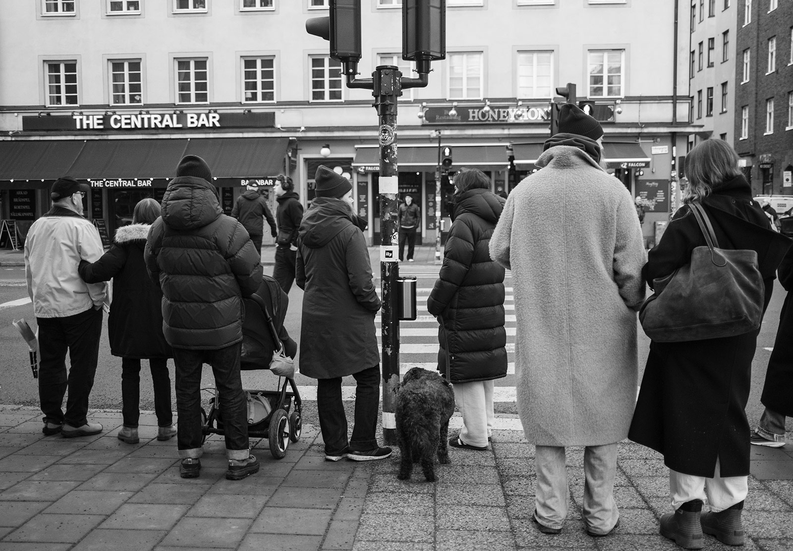 People stood at crossing in big coats