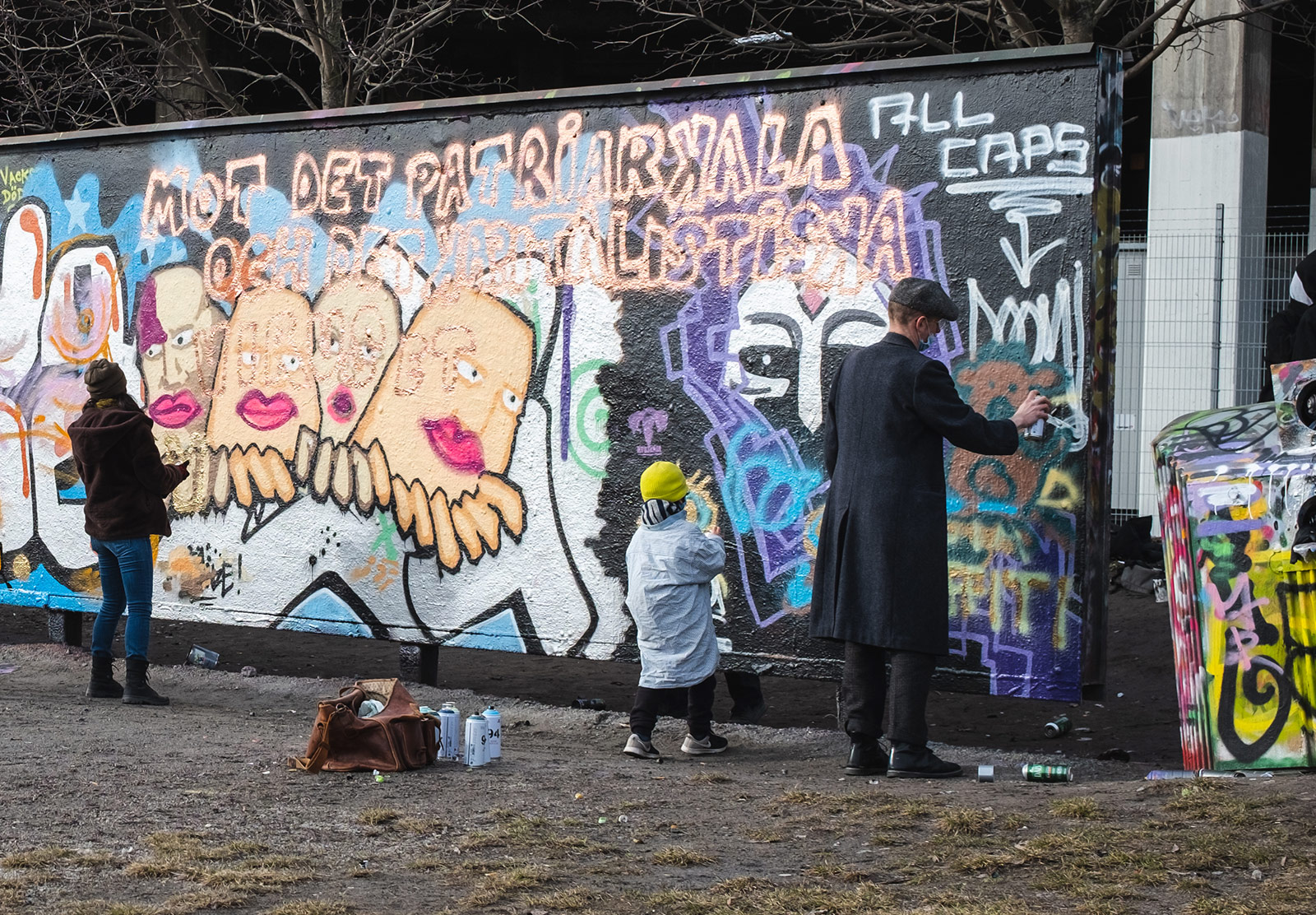 Kid spray painting with parent