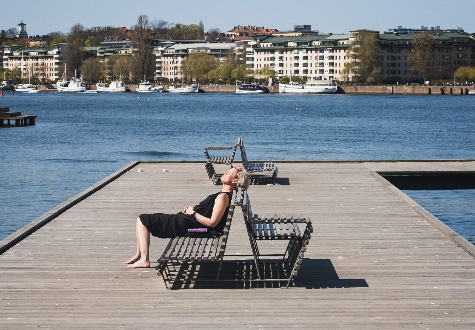 Woman sunbathing on a bench