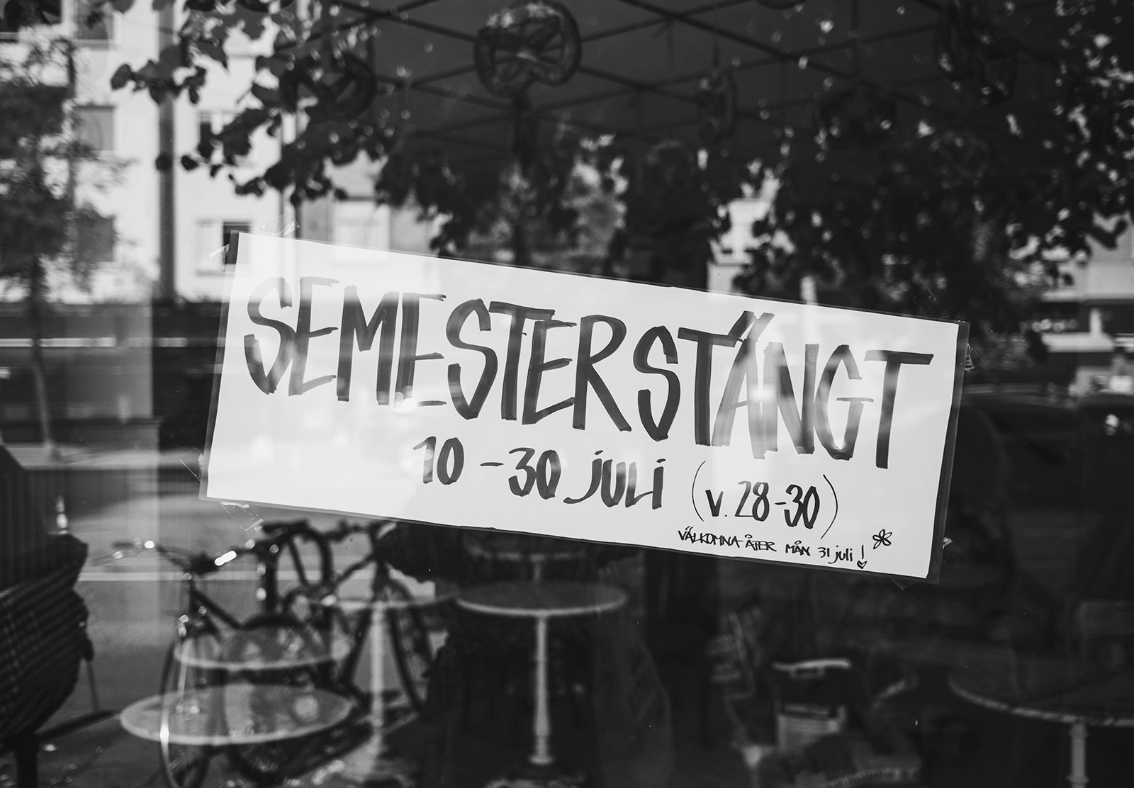 Semesterstängt sign on window