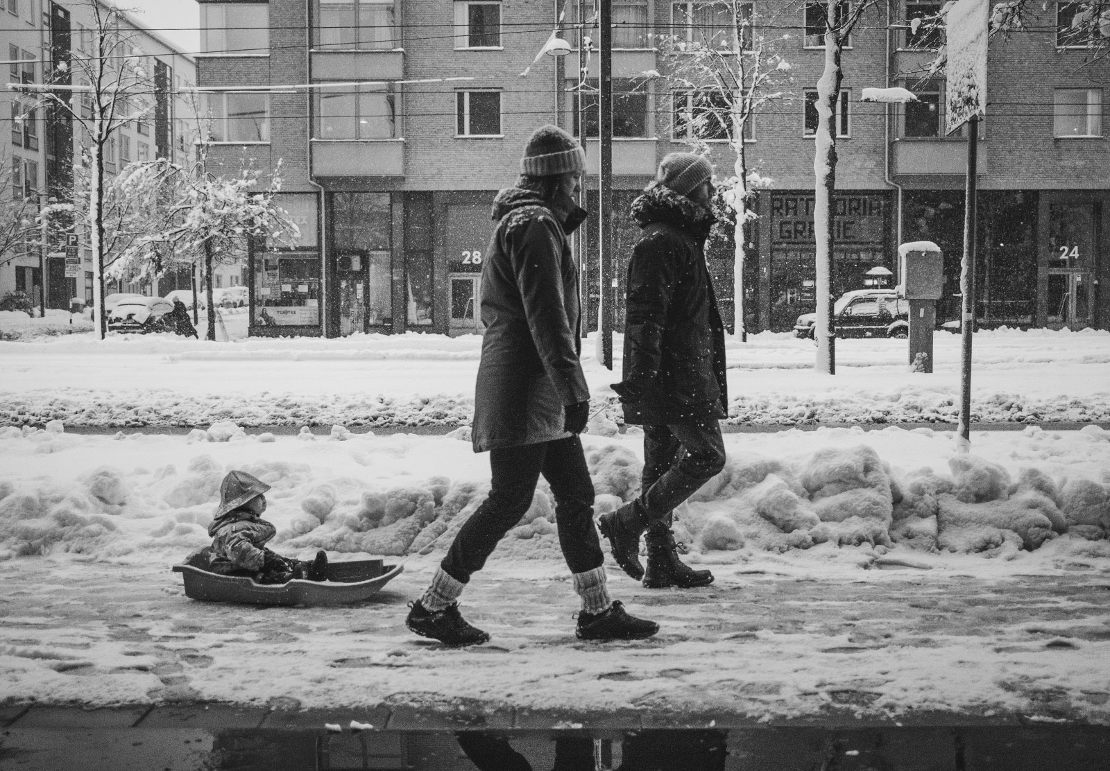 Couple pulling child in sledge