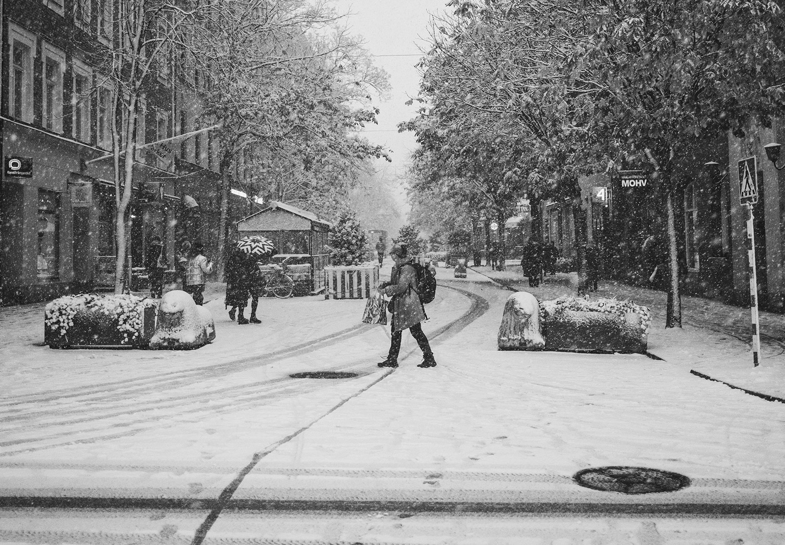 Woman walking across snowy road