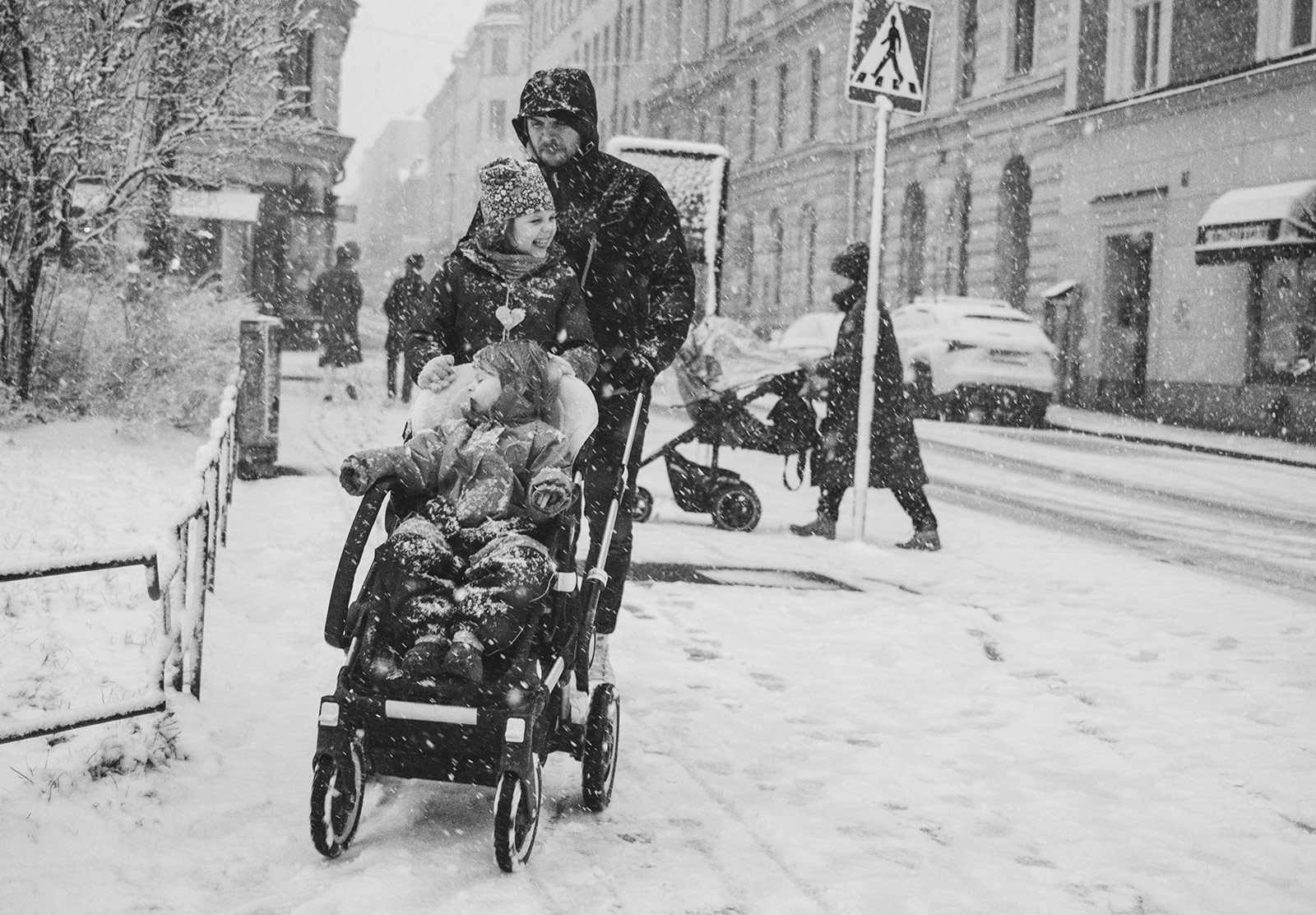 Man pushing pram through snow