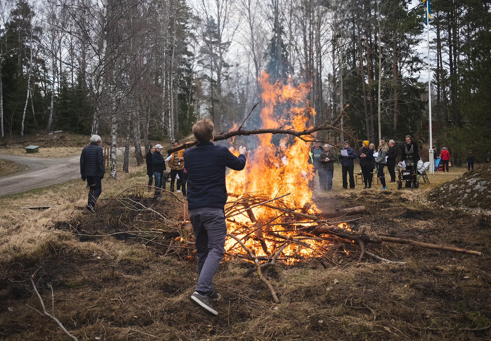 Man putting log on bonfire