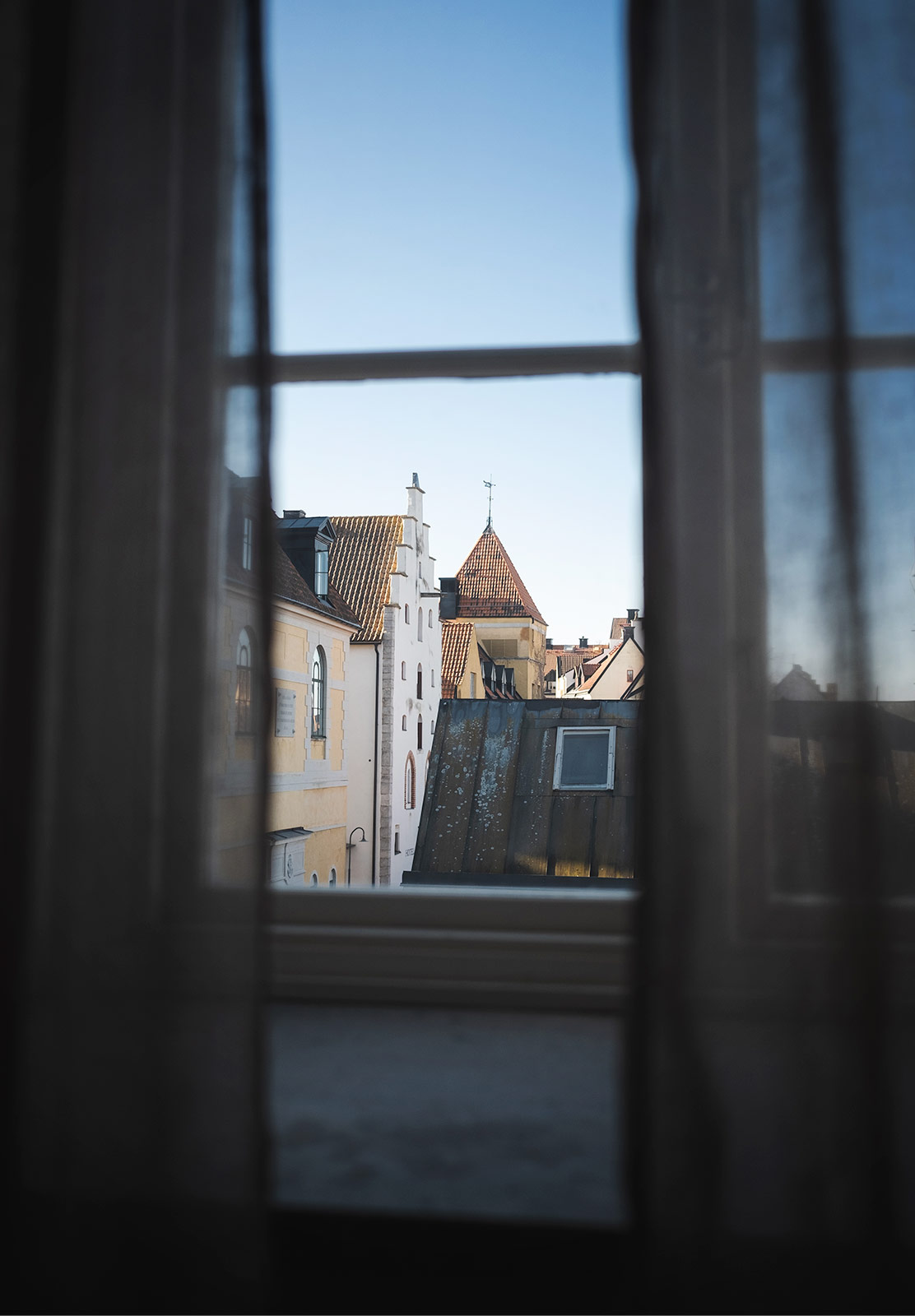 View of buildings through curtains