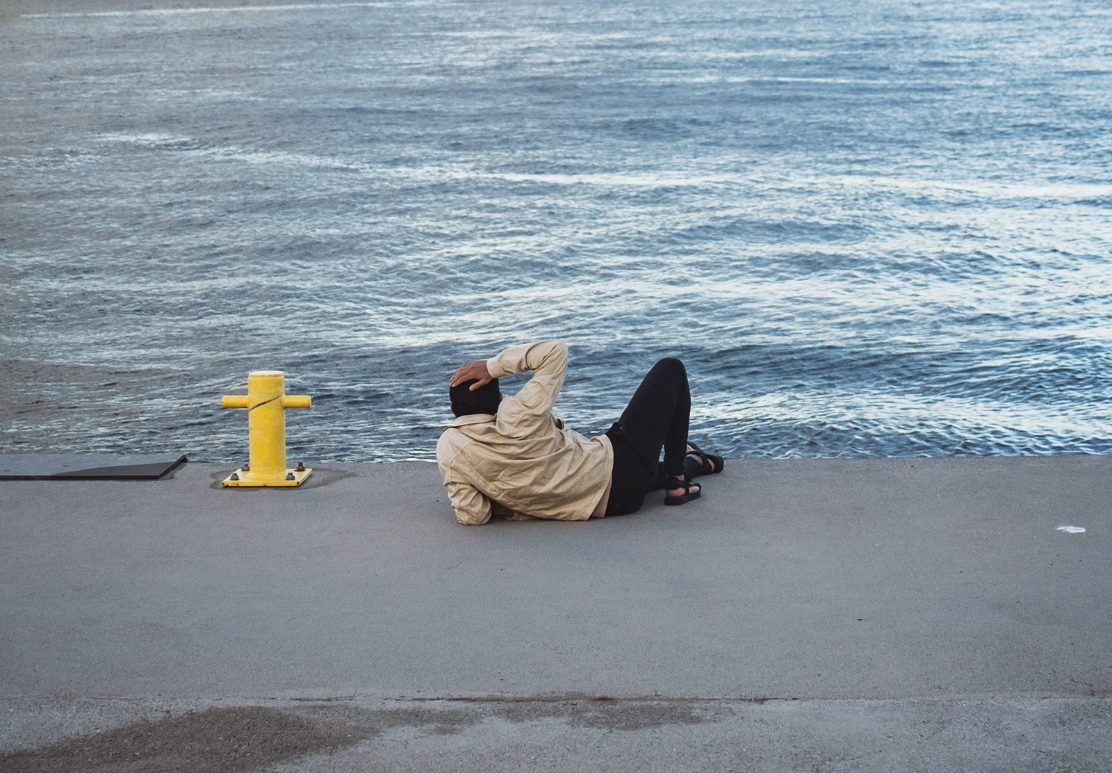 Man laying on side watching water
