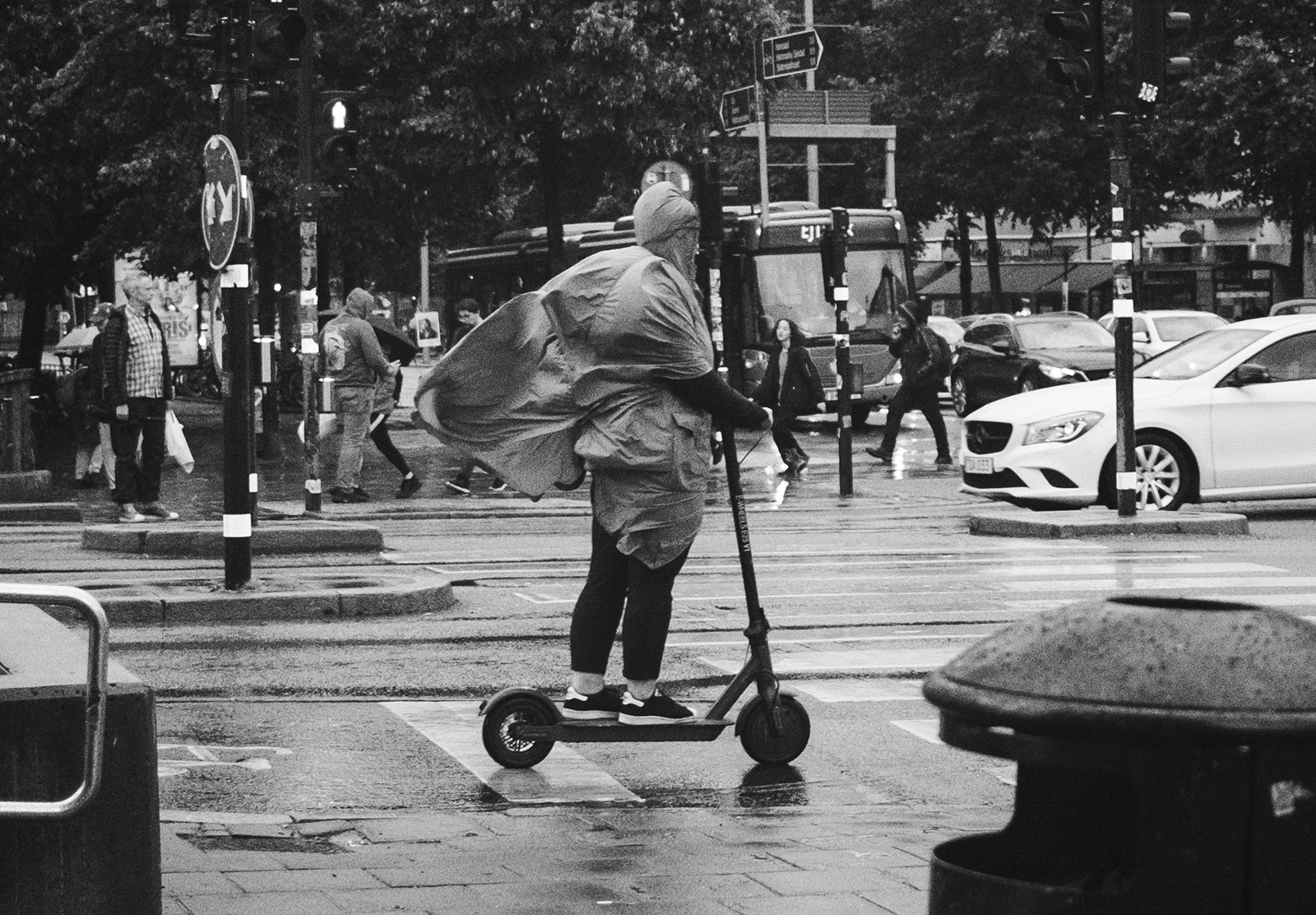 People on a scooter in raincoat