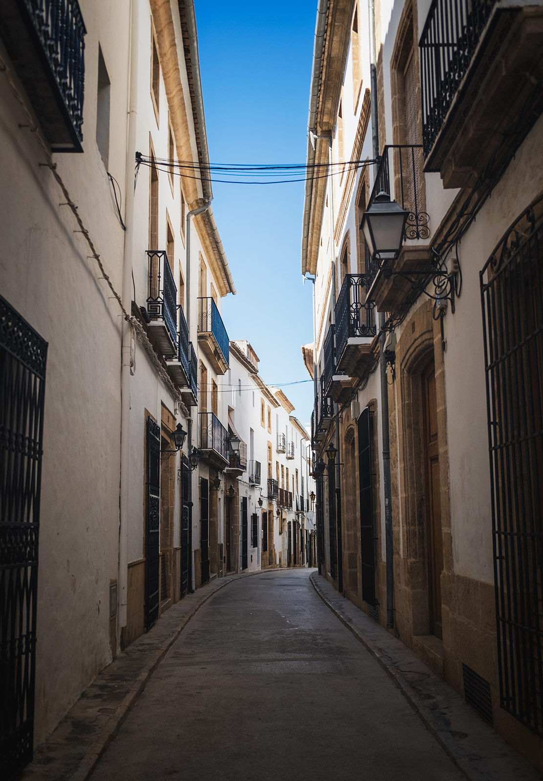 Shaded streets below a clear blue sky