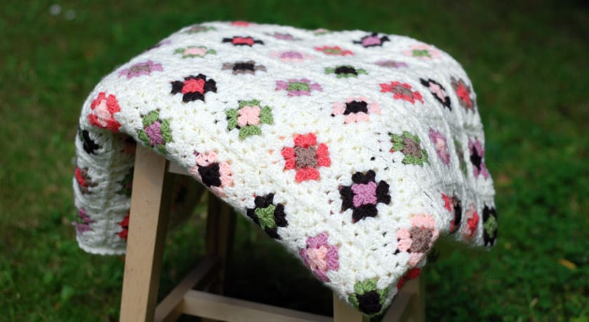 Cream crochet blanket on a stool