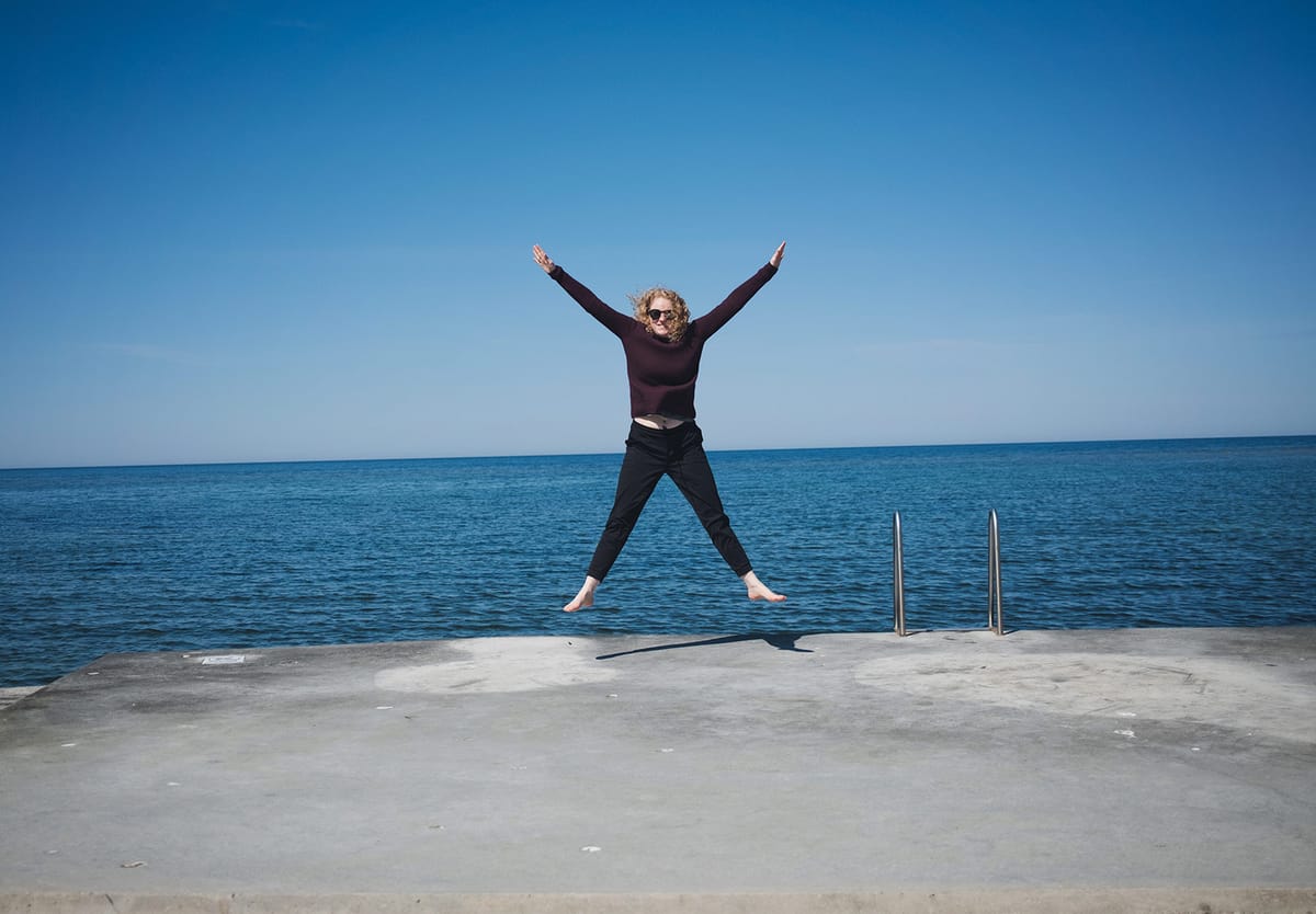 Woman jumping next to sea