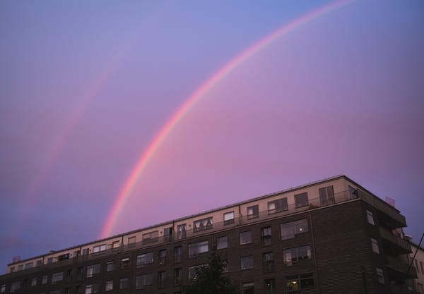 Pink rainbow in blue sky