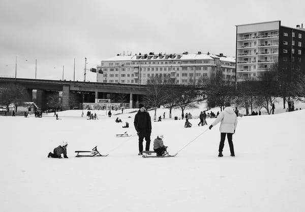 Parents pulling children on sledges
