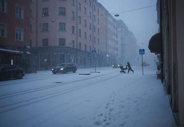 Person crossing the road with pram in a blizzard